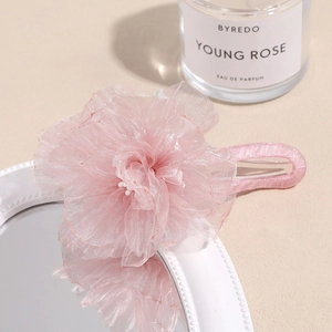 Detailed view of the layered pink organza flower hair claw with a soft 3D petal texture