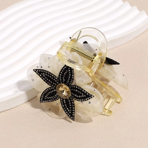 Detailed view of mesh flower hair claw with rhinestone center and resin base clips