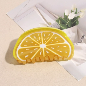 Dettaglio di un fermaglio per capelli a forma di limone con motivo a frutti gialli traslucidi