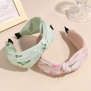 Diademas anchas con nudos y flores en verde claro y rosa para el peinado de mujeres