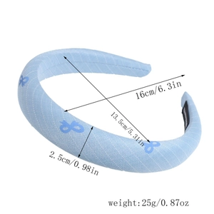 Detail view of light blue fabric headband with bow patterns and sponge filling dimension