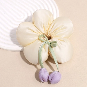 Détail du chouchou fleur en soie crème avec ruban vert et breloques tulipes