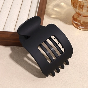 Macro detail of large matte black square hair claw clip with rectangular hollow design