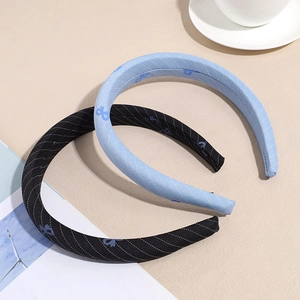 Detailed view of navy and light blue striped fabric headbands on a textured desk