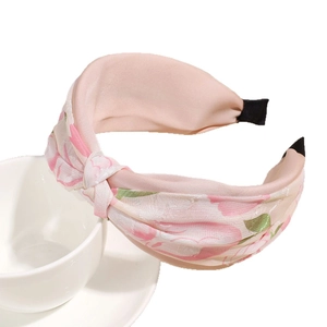 Diadema ancha anudada con estampado floral rosa pálido para un peinado con volumen