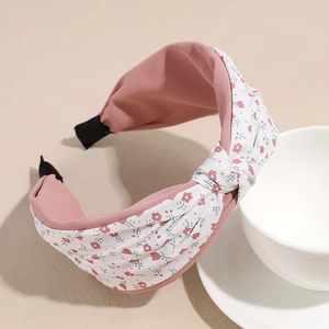 Detalle de diadema trenzada con estampado floral blanco y forro rosa suave