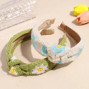 Knitted daisy headbands with twist knot detail in green and beige floral patterns