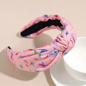 Détail du serre-tête rose avec imprimé papillons et doublure intérieure noire