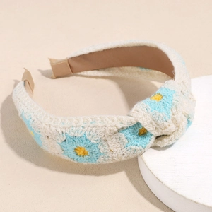 Close-up of knit flower headband featuring daisy patterns and soft crochet texture