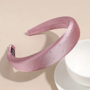 Detail of pink satin padded headband with rhinestones and a hand made label