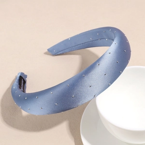 Close-up of fog blue satin headband with silver studs and thick sponge padding