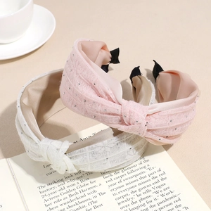 Lace rhinestone wide knotted headbands in pink and beige on an open magazine