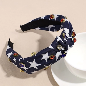 Close-up of navy blue star print headband with colorful rhinestones and gold prongs