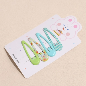 Detail of four drop-shaped snap clips with fruit and dot prints on a cute display card