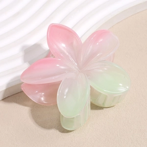 Dettaglio di una pinza per capelli a fiore con sfumatura rosa e verde e finitura opaca