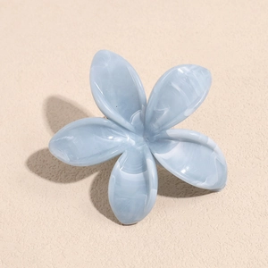 Close-up of light blue marble textured five-petal flower hair claw with matte finish
