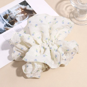 Chouchou fleuri avec bordure en dentelle présenté sous un angle de 45 degrés doux
