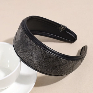 Gros plan du serre-tête large en cuir PU avec motif matelassé sur une tasse à café