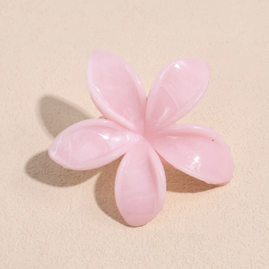 Macro detail of pink marble texture on five-petal frangipani flower hair claw clip