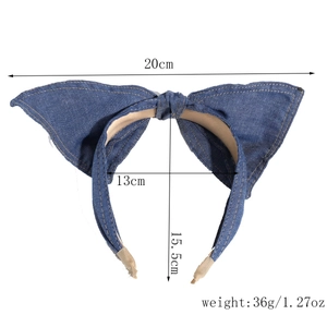 Detailansicht des dunkelblauen Denim-Haarreifens mit weißer Kontrastnaht und beigen Endstücken