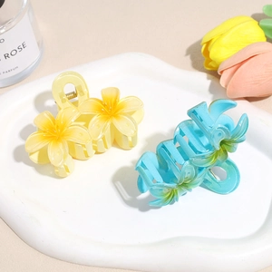 Pinces à cheveux élégantes en acrylique forme frangipanier en jaune et bleu sur plateau