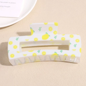 Detail view of cream square hair claw clip featuring bright lemon and leaf prints