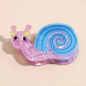 Detail of a cute translucent snail hair claw clip with blue spiral and yellow flower