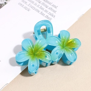 Détail d'une pince à cheveux en acrylique bleu translucide avec un dégradé de vert au centre