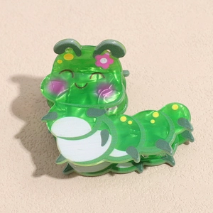 Close-up of green caterpillar hair claw clip with marble texture and floral details