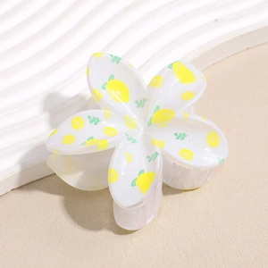 Detail of floral hair claw clip with lemon pattern on white acrylic five-petal design