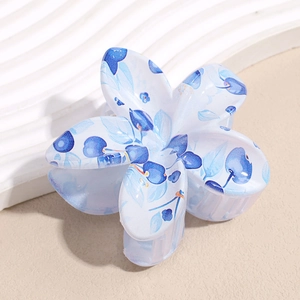 Close-up of a floral hair claw clip with blue berry and green leaf print patterns