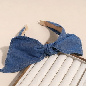 Nahaufnahme von breitem Denim-Haarreif mit gelben Ziernähten und weichem Stoff auf der Innenseite