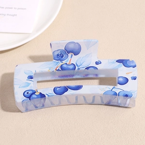 Detail of a rectangular blue hair claw clip with fresh blueberry and floral prints