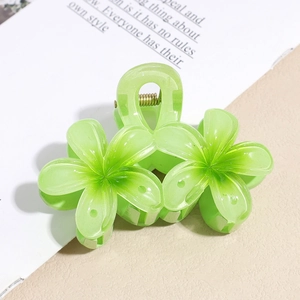 Détail de la pince à cheveux fleur en acrylique vert clair avec ressort doré