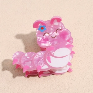 Detail view of pink caterpillar hair claw clip with a glossy finish and blue flower