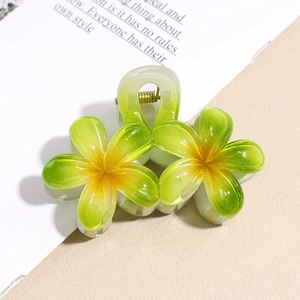 Dettaglio della pinza per capelli a fiore in acetato verde con molla in metallo oro