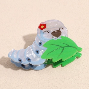 Close-up of a blue cartoon caterpillar hair claw clip with green leaf and flower detail