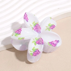 Detailed macro view of white floral hair claw with purple grape patterns and glossy finish