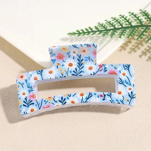 Detail view of light blue square hair claw clip with daisy print and matte finish
