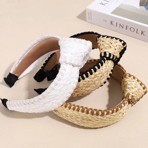 Close-up of three bohemian knotted straw headbands in white and natural woven textures