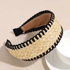 Detail of bohemian straw woven headband featuring black stitched edges and knotted design