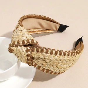 Detail of straw woven headband featuring a top knot and coffee embroidered edges