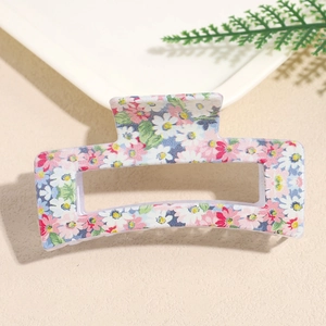 Detailed macro view of a square floral hair claw clip with white daisy and pink prints