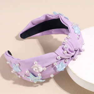 Detailed view of purple fabric headband with starfish, white pearls and sea shells