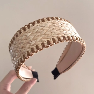 Detail of bohemian woven raffia headband showing straw texture and dark brown accents
