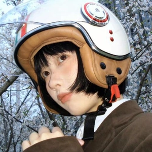 Gros plan d'un casque moto rétro blanc avec des rayures et un rembourrage en cuir marron