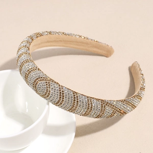 Nahaufnahme eines luxuriösen breiten Stirnbands mit Glitzersteinen und Wellenstruktur