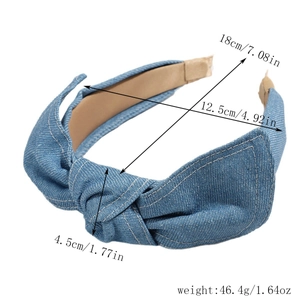 Detail shot of blue denim knotted headband showing dimensions and textile texture