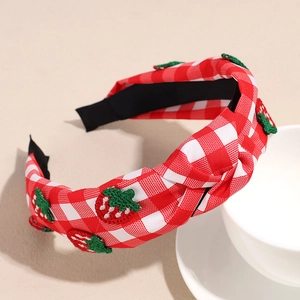 Detailed view of wide strawberry embroidered gingham headband with a top knot and non-slip lining