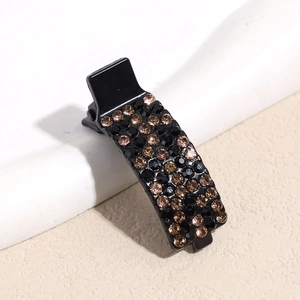 Detailed view of a small black hair claw clip with sparkling brown and black rhinestones